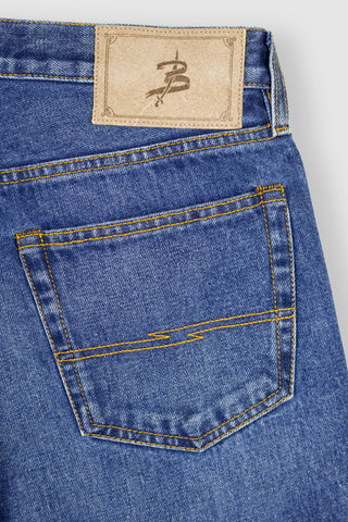 Detailed view of Barbanera Bandito jeans leather patch with branding engraving on the back waistband