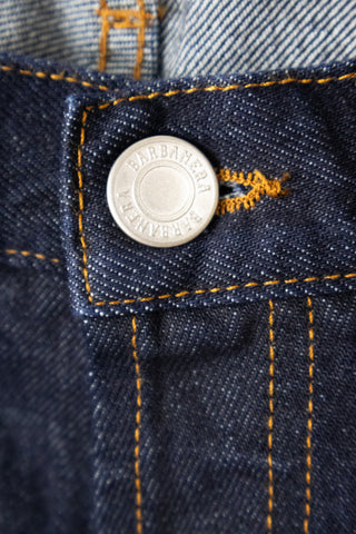 Detailed close-up of the branded stud button on Barbanera Bandito dark rinsed jeans, highlighting the metallic finish and engraved logo on the deep indigo denim.