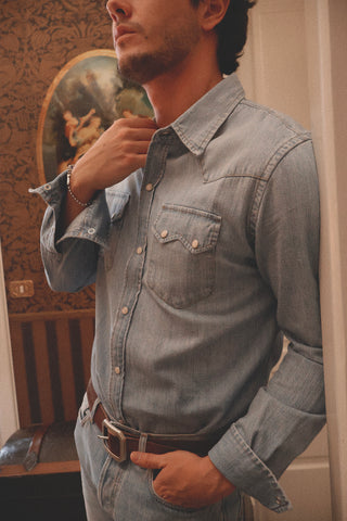 Close-up lifestyle detail of the Barbanera Carlito light blue denim shirt, highlighting the fabric texture, stitching, and Western-inspired design elements.