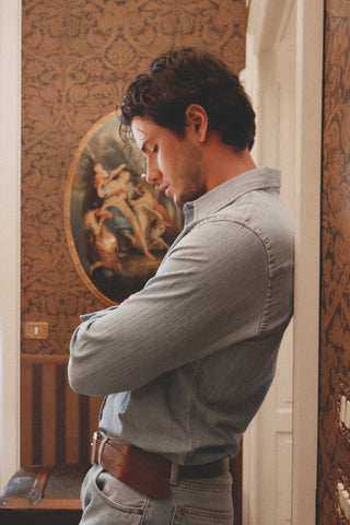 Side view of the Barbanera Carlito light blue denim shirt in a lifestyle setting, showcasing the relaxed fit and Western-style detailing.