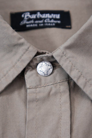 Close-up of a silver concho button on the Barbanera Clint sand western shirt, showcasing intricate detailing and stitching on the sandy beige fabric.