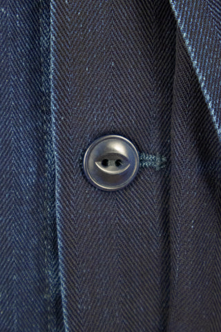 Close-up of the Barbanera Jericho rinsed blue overshirt fabric showcasing detailed herringbone weave pattern and button.