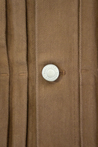 Close-up of a stud button on the Barbanera Neil camel selvedge denim jacket, highlighting the metallic hardware and reinforced stitching on the rugged denim fabric.