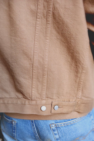Lifestyle close-up detail of the Barbanera Neil camel selvedge denim jacket, focusing on the textured denim fabric, stitching, and hardware elements.