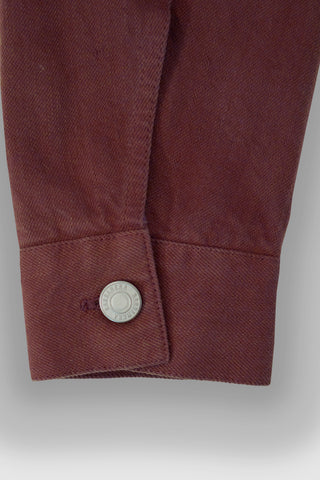 Close-up of the cuff on the Barbanera Neil dark red selvedge denim jacket, showcasing the button closure, stitching, and denim texture