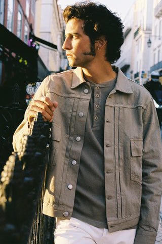 Lifestyle side view of the Barbanera Neil sand selvedge denim jacket worn casually outdoors, showing the jacket’s fit, light sandy color, and classic denim details in natural outdoor lighting.