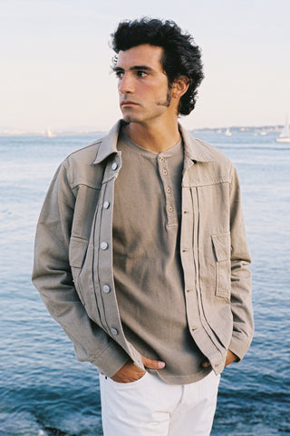 Lifestyle view of the Barbanera Neil sand selvedge denim jacket worn outdoors, highlighting the light sandy tone, structured fit, and classic denim styling.