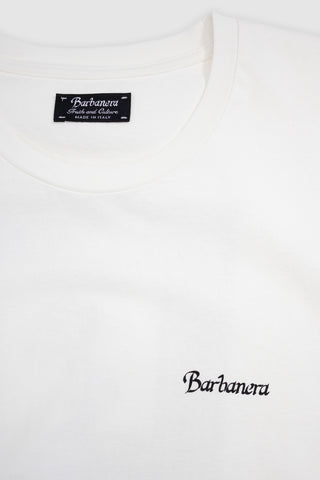 Close-up of the chest area on the Barbanera Vince white tee, showing the black vintage-style logo print on raw cotton fabric.