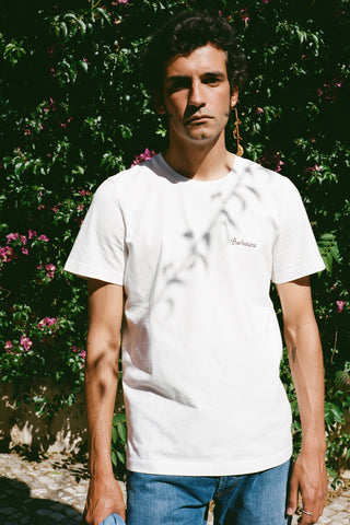 Lifestyle front view of a model wearing the Barbanera Vince blue bandana print tee, styled casually with jeans, showcasing the detailed blue bandana graphic on the back on a white raw cotton fabric.